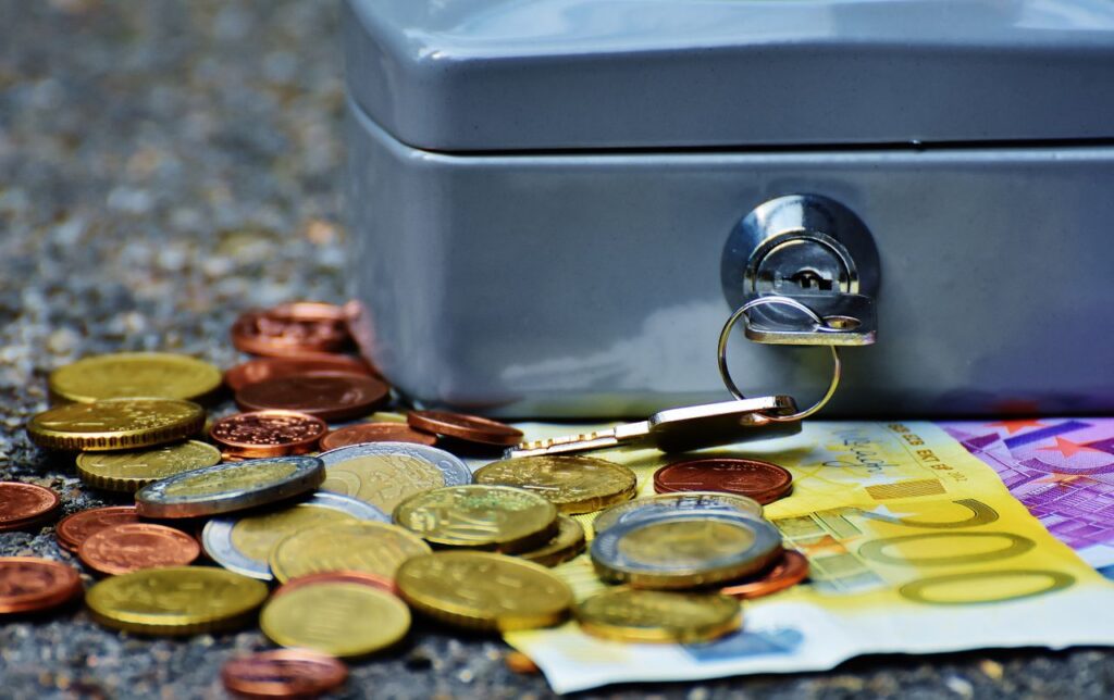 Close-up of a secure cash box with euro coins and banknotes, symbolizing wealth and financial security.